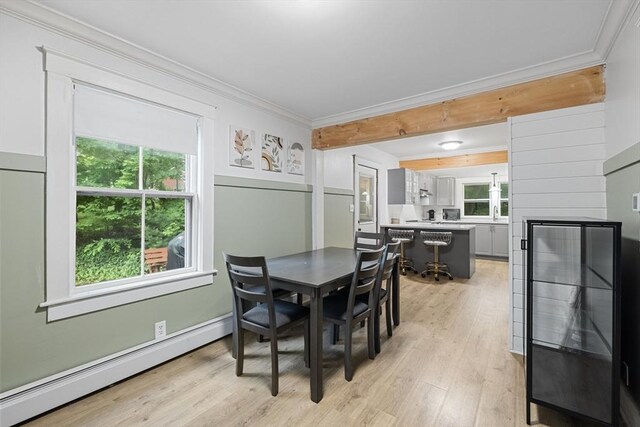 486 Franklin St, Reading, MA 01867 - dining space featuring a baseboard radiator, crown molding, light wood-style floors, and a fireplace