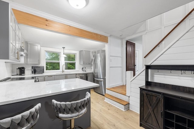 486 Franklin St, Reading, MA 01867 - kitchen with appliances with stainless steel finishes, light stone counters, a peninsula, light wood-style floors, and gray cabinets