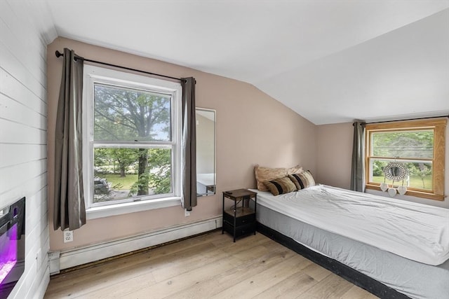 486 Franklin St, Reading, MA 01867 - bedroom with a baseboard heating unit, vaulted ceiling, light wood-style flooring, and multiple windows
