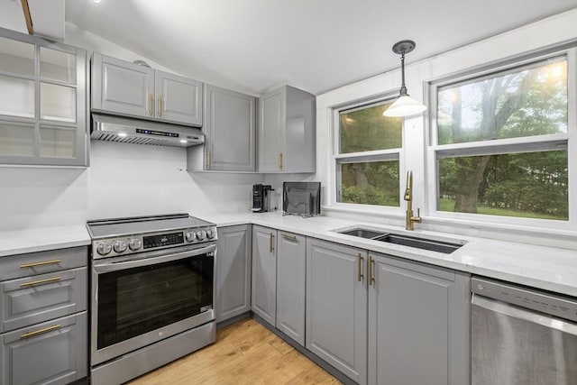 486 Franklin St, Reading, MA 01867 - kitchen with gray cabinetry, stainless steel appliances, extractor fan, vaulted ceiling, and glass insert cabinets