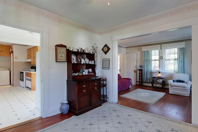 entrance foyer featuring light wood finished floors, washer / clothes dryer, and crown molding