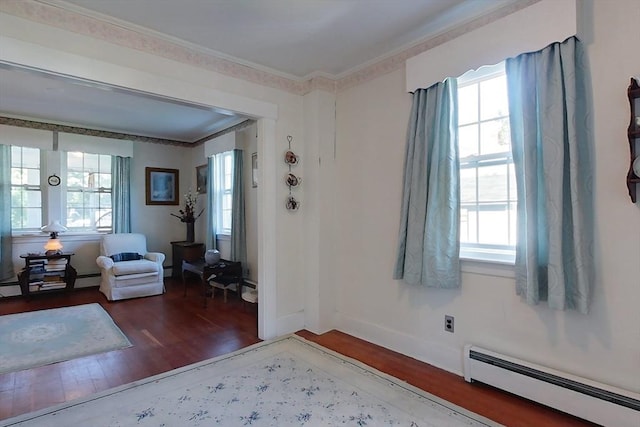 entryway with ornamental molding, plenty of natural light, baseboard heating, and wood finished floors