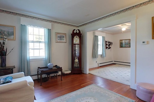 entrance foyer featuring ceiling fan, a baseboard heating unit, and wood finished floors