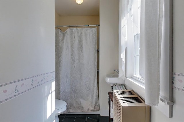 bathroom with tile patterned flooring, a shower with shower curtain, a sink, and toilet