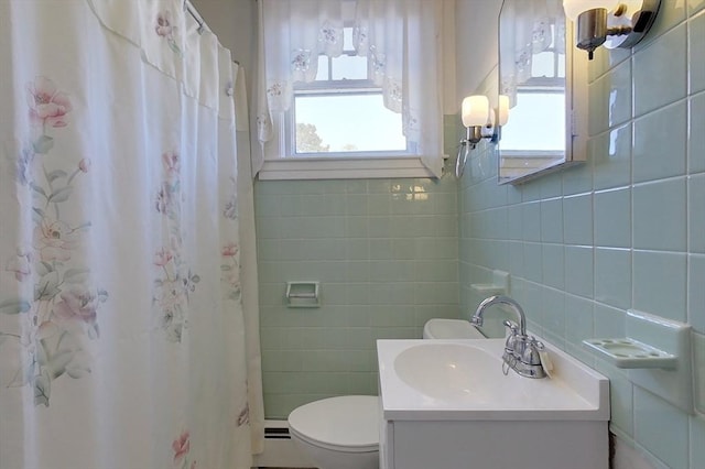 full bath with curtained shower, tile walls, toilet, and vanity