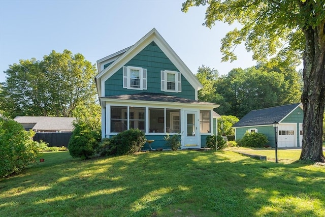 view of front of property with an outbuilding, a front lawn, a sunroom, and a garage