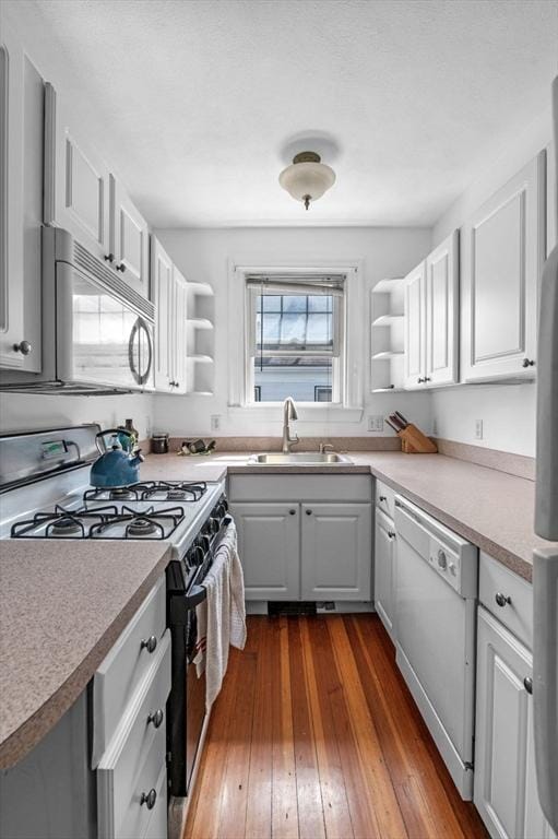 71 Ocean Ave Unit 3, Salem, MA 01970 - kitchen with dishwasher, open shelves, gas stove, dark wood finished floors, and white cabinetry