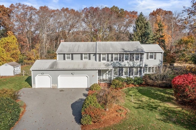 12 Checkerberry Cir, Sudbury, MA 01776 - view of front facade with asphalt driveway, a front lawn, a chimney, and a garage