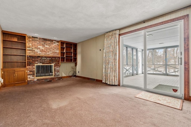 12 Checkerberry Cir, Sudbury, MA 01776 - unfurnished living room with carpet floors, a fireplace, a textured ceiling, and built in features