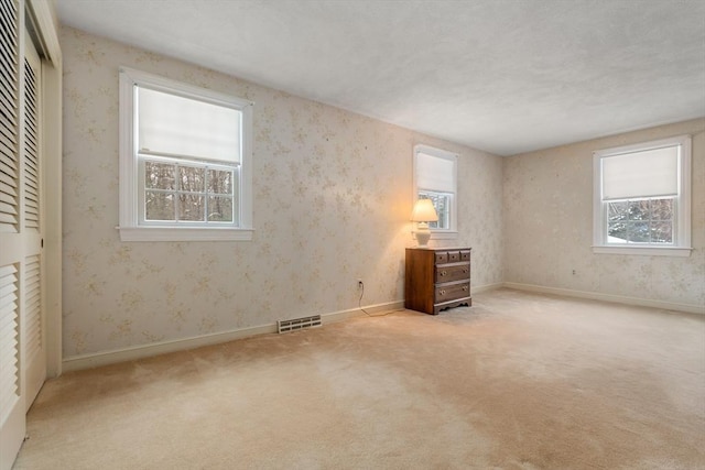 12 Checkerberry Cir, Sudbury, MA 01776 - unfurnished bedroom featuring multiple windows, carpet, and a closet