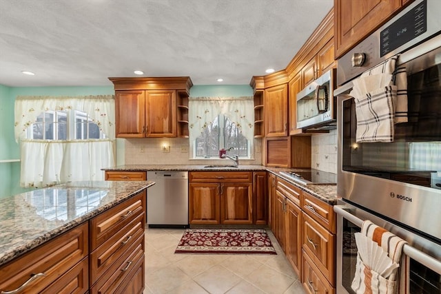 12 Checkerberry Cir, Sudbury, MA 01776 - kitchen featuring stainless steel appliances, open shelves, brown cabinetry, stone countertops, and decorative backsplash