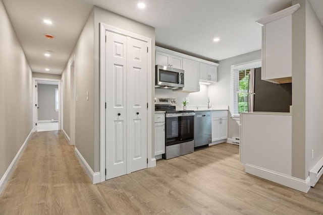 1029 Iyannough Rd Unit 9B, Barnstable, MA 02601 - kitchen with appliances with stainless steel finishes, light wood-type flooring, white cabinets, recessed lighting, and baseboards