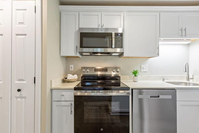 1029 Iyannough Rd Unit 9B, Barnstable, MA 02601 - kitchen with appliances with stainless steel finishes, a sink, white cabinetry, and light countertops