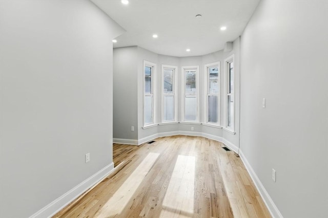 unfurnished room with light wood finished floors, recessed lighting, and baseboards