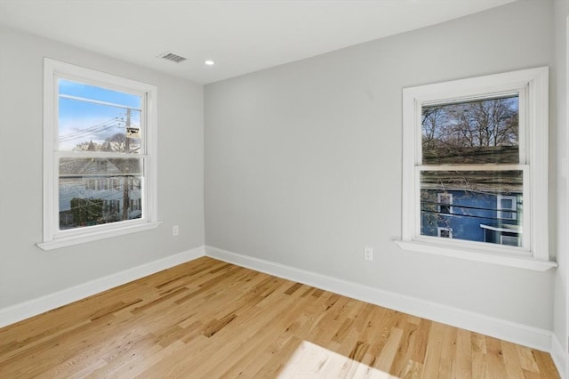 empty room with baseboards, wood finished floors, and recessed lighting