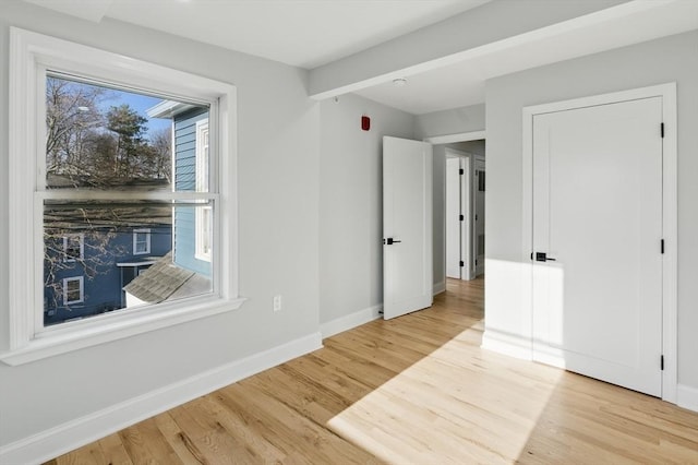 unfurnished bedroom featuring light wood finished floors and baseboards