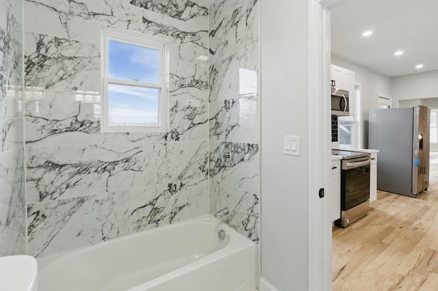 bathroom with vanity, wood finished floors, recessed lighting, and shower / bath combination