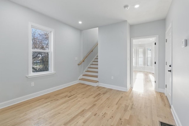unfurnished room with stairs, a smoke detector, light wood-type flooring, recessed lighting, and baseboards