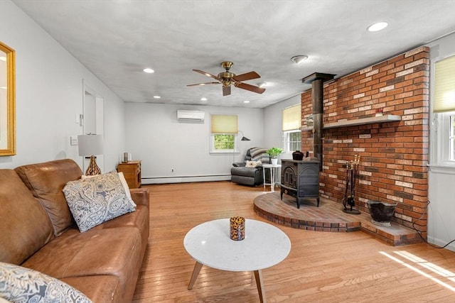 5 Hansen Ave, Burlington, MA 01803 - living area with a wood stove, a baseboard radiator, hardwood / wood-style flooring, a wall mounted AC, and recessed lighting