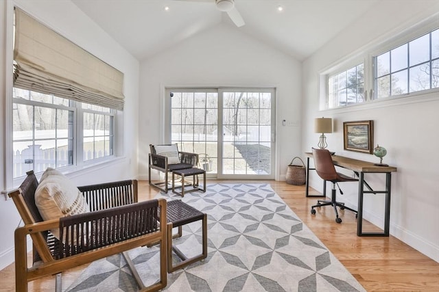 office featuring light wood-type flooring, baseboards, high vaulted ceiling, and a healthy amount of sunlight