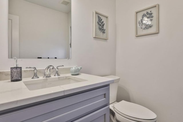 bathroom with visible vents, toilet, and vanity