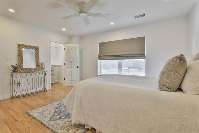 bedroom with light wood-type flooring, visible vents, a walk in closet, a ceiling fan, and recessed lighting