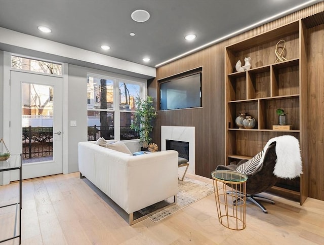 sitting room with wooden walls and light hardwood / wood-style flooring