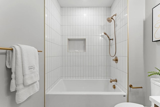 full bathroom featuring vanity, tiled shower / bath combo, and toilet