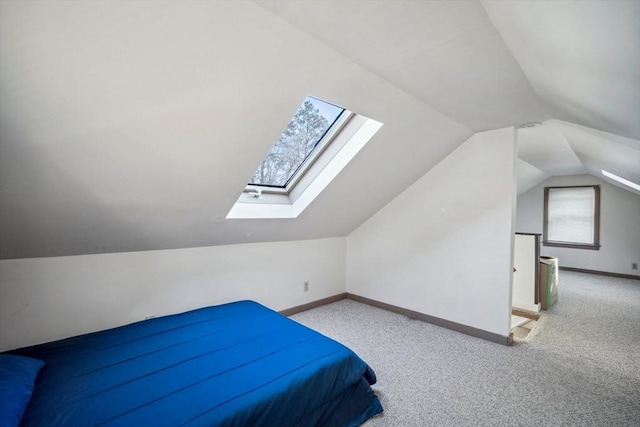 carpeted bedroom with lofted ceiling and baseboards