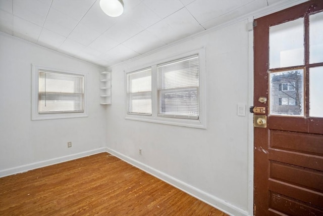 foyer featuring ornamental molding, baseboards, and wood finished floors