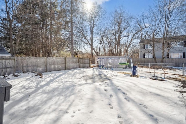 snowy yard featuring a fenced backyard