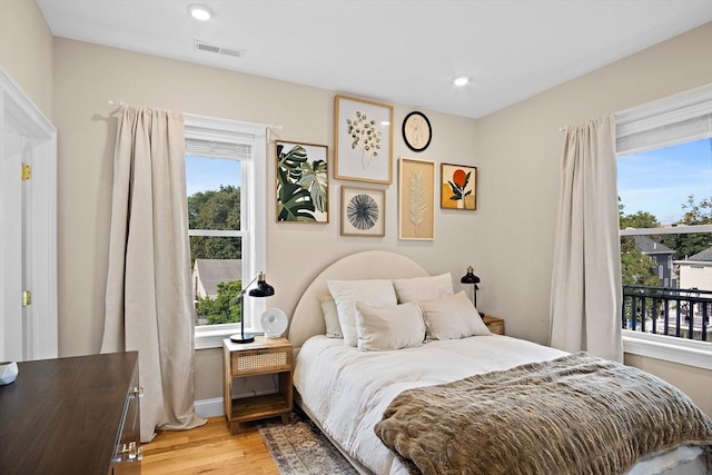 bedroom with light wood-type flooring and multiple windows