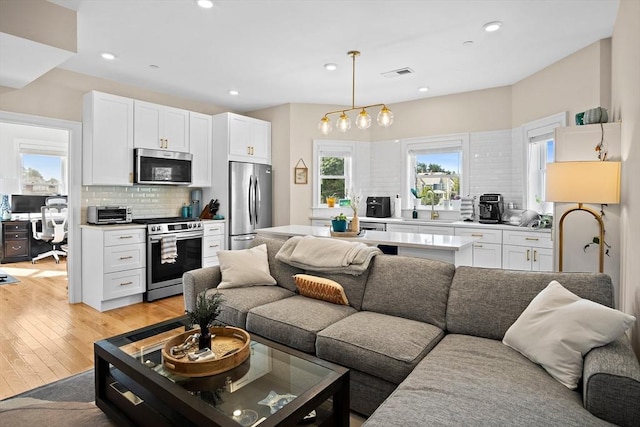 living room with light hardwood / wood-style flooring and sink