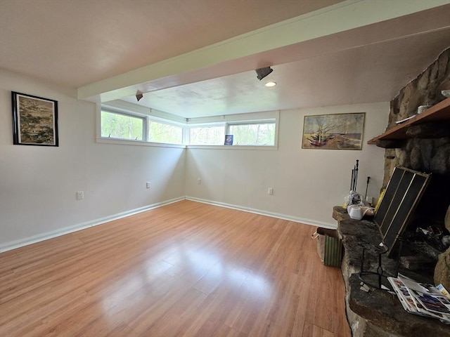 unfurnished living room featuring light wood-style floors, baseboards, and a fireplace