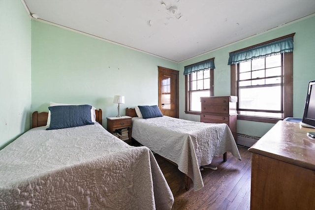 bedroom featuring baseboard heating and hardwood / wood-style flooring