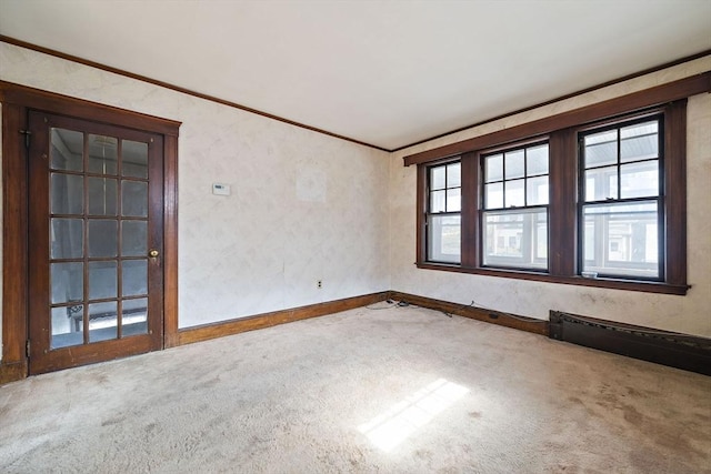 carpeted spare room with crown molding and baseboards