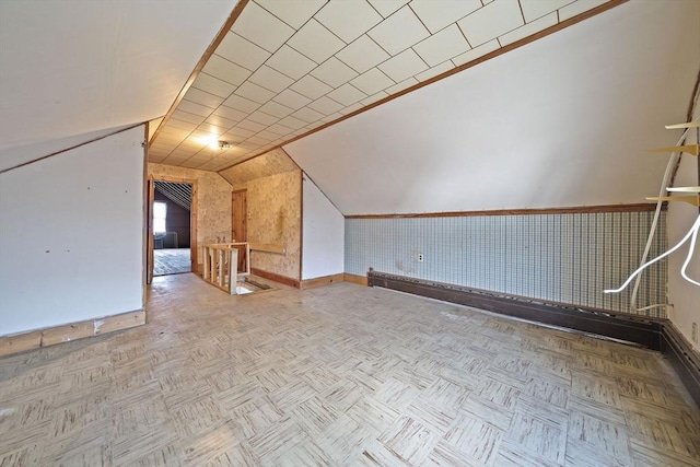 bonus room with baseboards and lofted ceiling