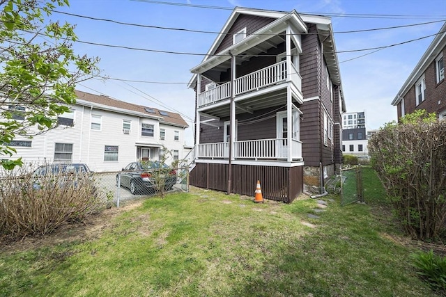 back of property with a lawn, fence, and a balcony