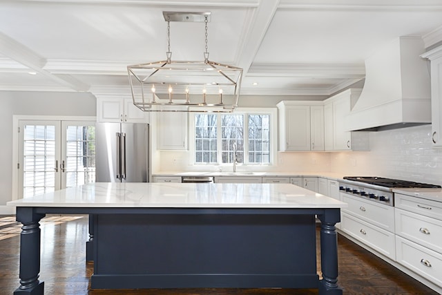 kitchen featuring stainless steel appliances, backsplash, coffered ceiling, custom range hood, and a kitchen island