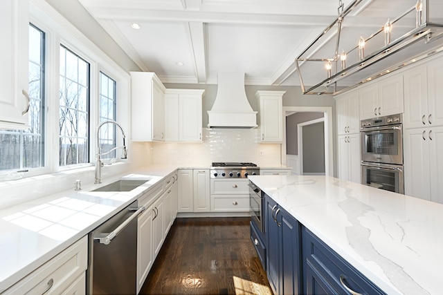 kitchen with dark hardwood / wood-style flooring, stainless steel appliances, custom range hood, blue cabinets, and beam ceiling