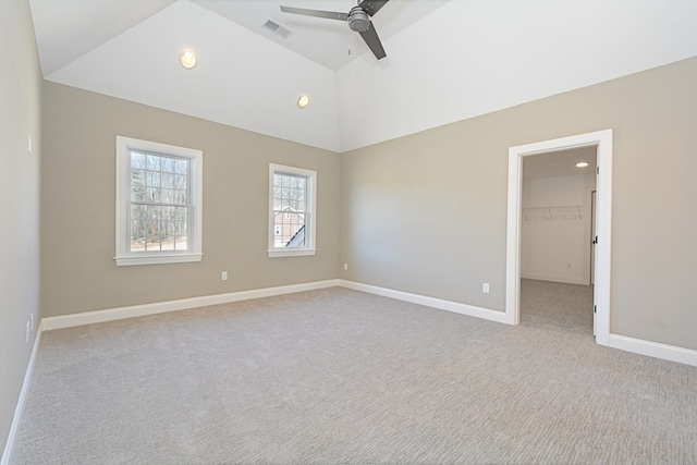 carpeted spare room with ceiling fan and vaulted ceiling