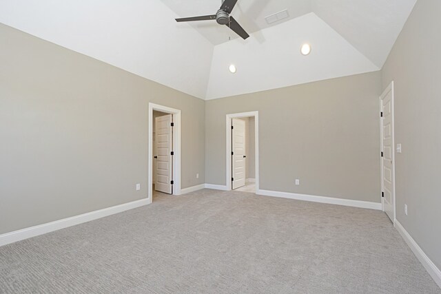 unfurnished bedroom featuring ceiling fan, high vaulted ceiling, connected bathroom, and light colored carpet