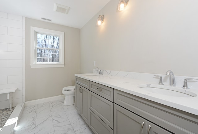 bathroom with toilet, dual bowl vanity, and tile patterned flooring