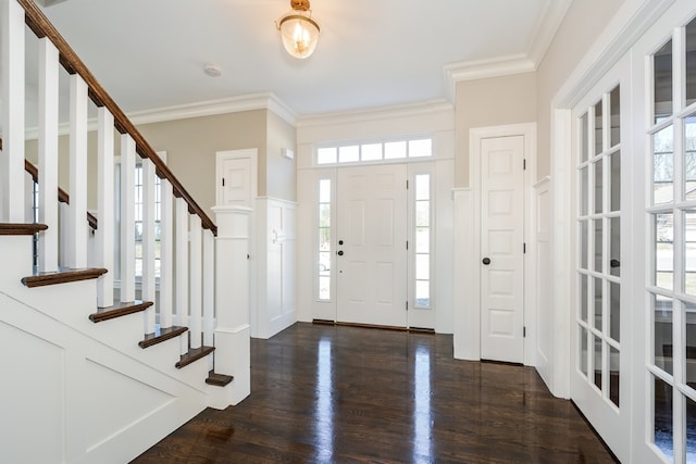 foyer entrance featuring dark hardwood / wood-style flooring, ornamental molding, and a healthy amount of sunlight