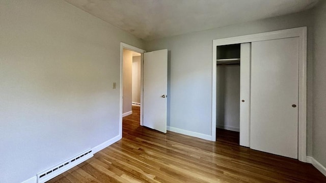 9 Brooks Rd, Sudbury, MA 01776 - unfurnished bedroom with a closet, baseboards, wood finished floors, and baseboard heating