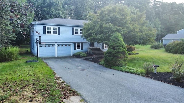 9 Brooks Rd, Sudbury, MA 01776 - split level home with aphalt driveway, an attached garage, and a front lawn