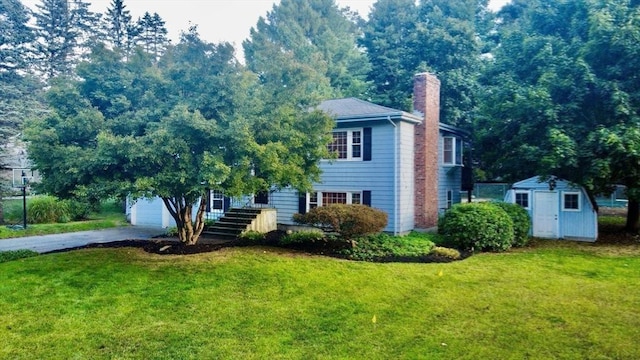 9 Brooks Rd, Sudbury, MA 01776 - view of front of house featuring a chimney, a front yard, aphalt driveway, and a shed