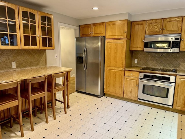 9 Brooks Rd, Sudbury, MA 01776 - kitchen with stainless steel appliances, light floors, recessed lighting, decorative backsplash, and glass insert cabinets