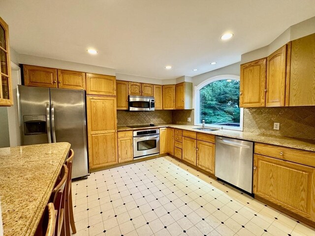 9 Brooks Rd, Sudbury, MA 01776 - kitchen featuring a sink, stainless steel appliances, light stone countertops, backsplash, and recessed lighting