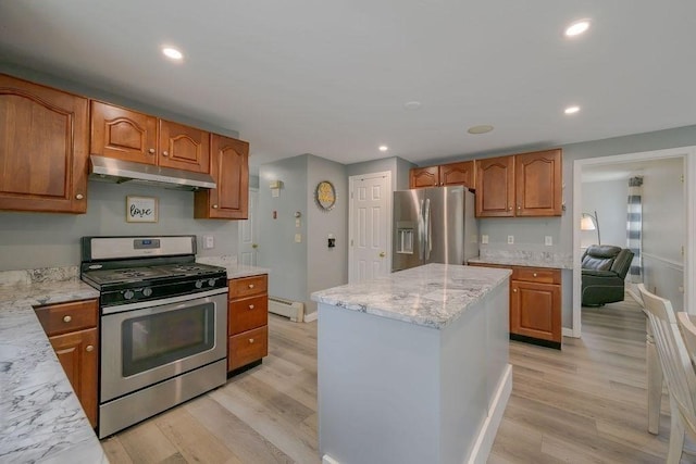 kitchen with stainless steel appliances, under cabinet range hood, baseboard heating, light wood-style floors, and light stone counters